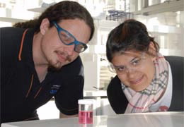 Jack Goralewski and Daniela Fierro posing with a sample in the lab at ANSTO