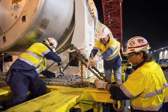 Transport workers securing waste on vehicle